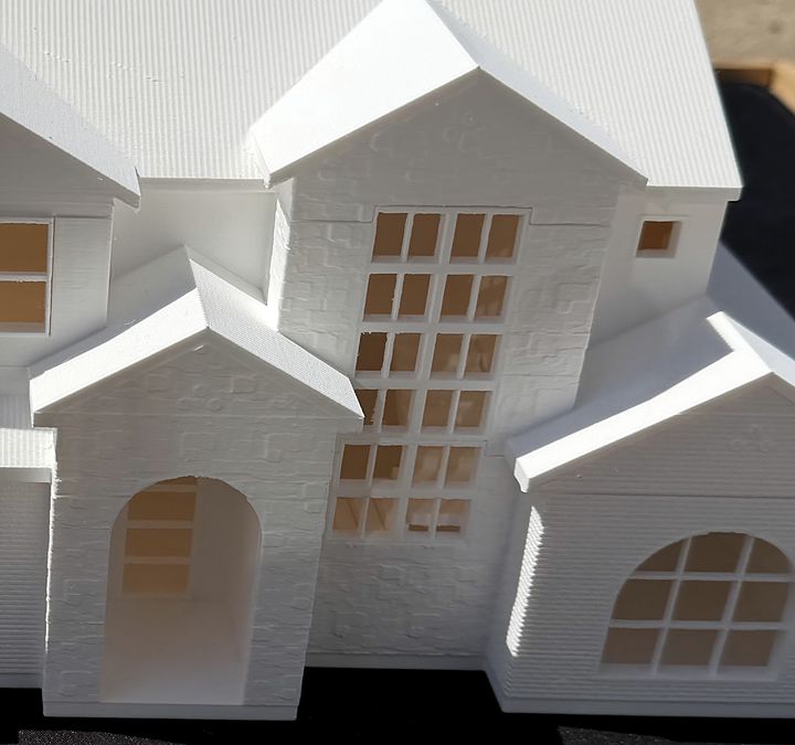 Close-up of the Adeline model by BR Custom Homes: a tall window grid, an arched entry and textured gables